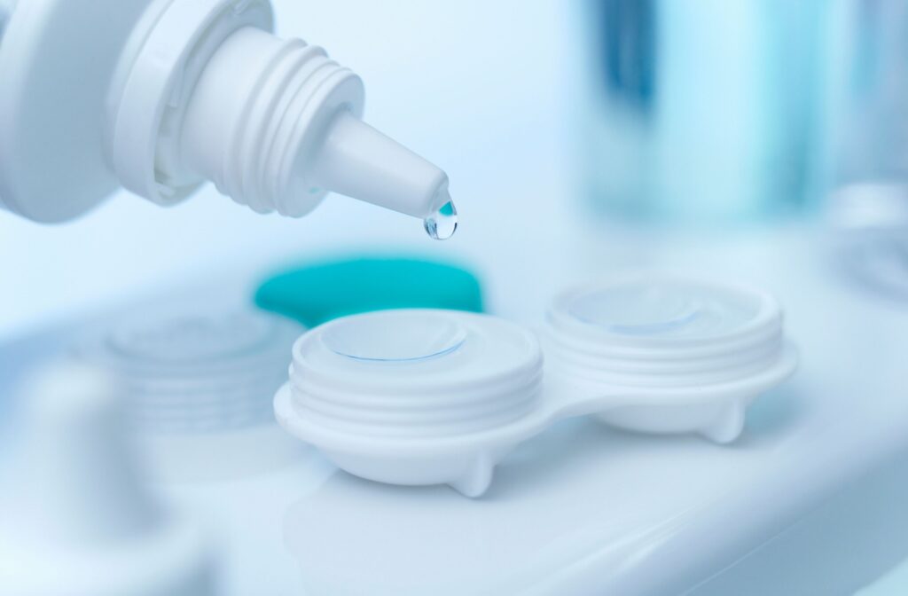 ontact lens solution being pouring into a contact lens case with contact lenses inside.