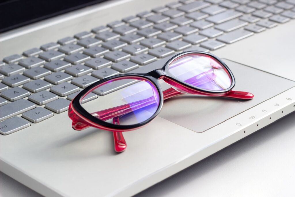 A pair of glasses sitting on a laptop keyboard.